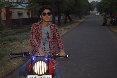 Portrait of smiling young woman standing on road