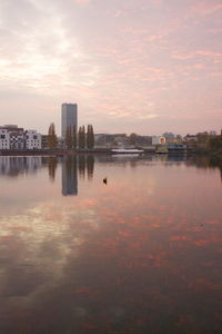 Reflection of buildings in river at sunset