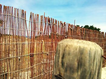 Wooden posts in traditional windmill against sky