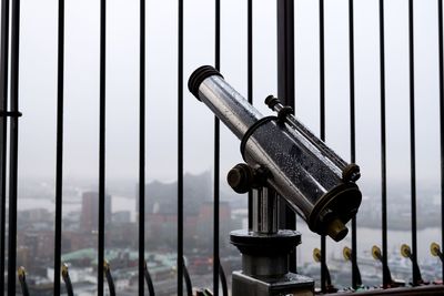 Coin-operated binoculars by window during rainy season