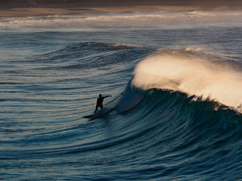 Person surfing on waves at sea