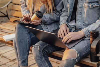 Working together in  serene park, a man and woman engaged in productive work with laptop and tablet