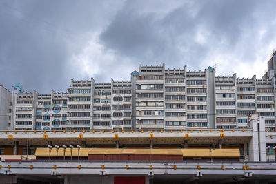 Buildings in city against cloudy sky