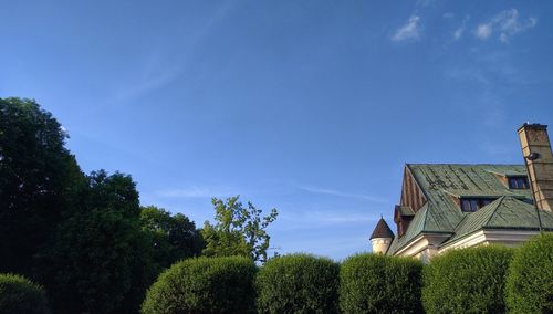 Low angle view of trees and house against sky