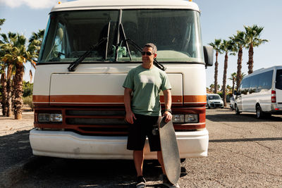 Full length of man standing by camper van
