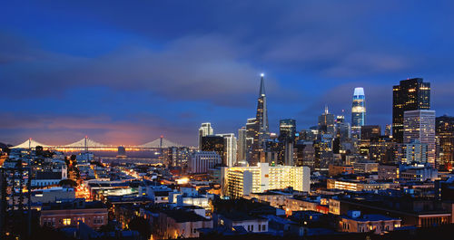High angle view of illuminated buildings against cloudy sky