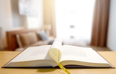 Close-up of open book on table at home