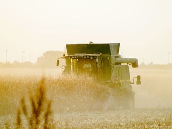 Tractor on field against clear sky