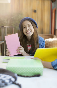 Portrait of smiling woman holding table