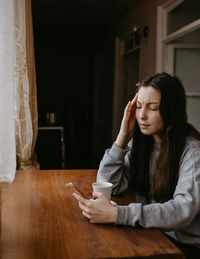 Young woman sitting on floor at home