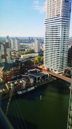 Bridge over river amidst buildings in city against sky