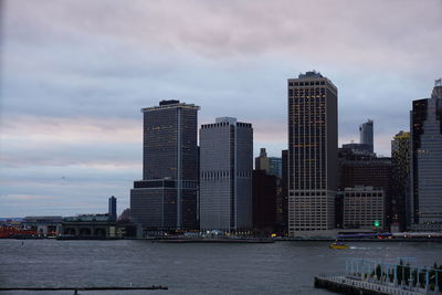 Modern buildings by sea against sky in city