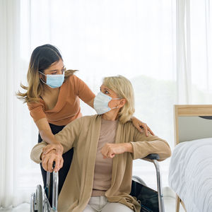 Daughter and mother wearing mask at hospital