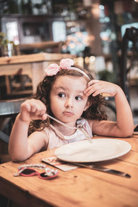 Close-up of girl sitting on table at restaurant