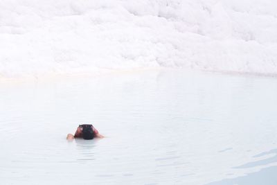 Woman sitting in shallow water