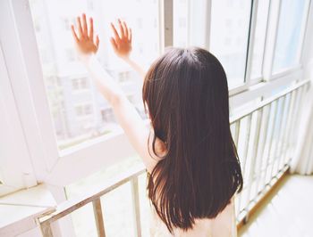 High angle view of girl touching glass window