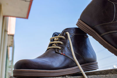 Low angle view of shoes against clear blue sky