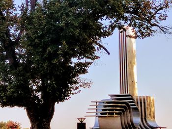 Low angle view of tree and building against sky