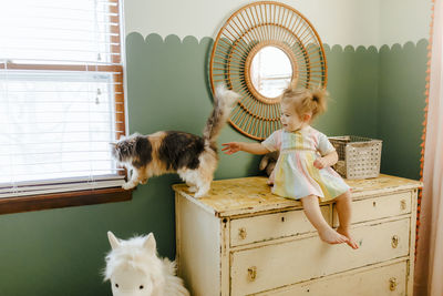 Toddler girl with her cat in her room