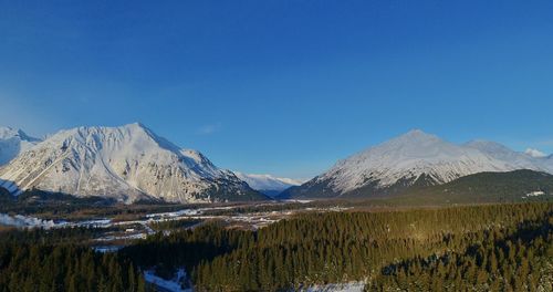 Scenic view of snowcapped mountains against clear blue sky