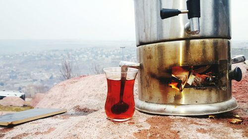 Turkish in tea glass by camping stove on rock