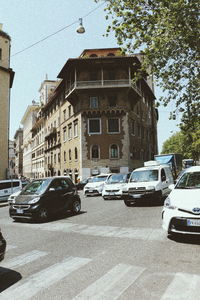 Cars on road against sky in city