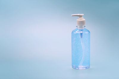 Close-up of glass bottle against blue background