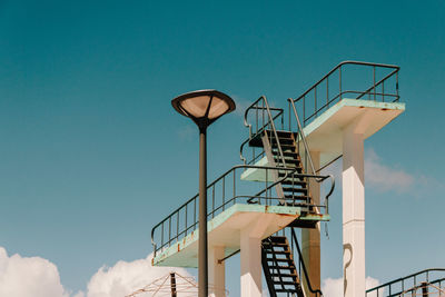 Low angle view of lamp post and staircase against sky