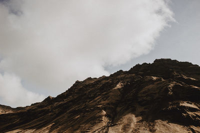 Low angle view of mountain against cloudy sky