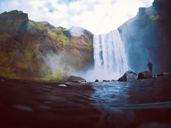 Scenic view of waterfall against sky