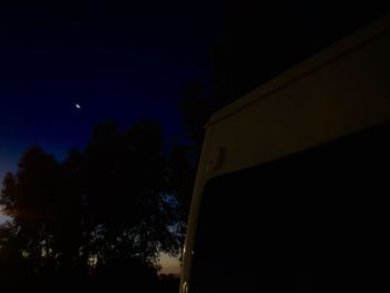 Low angle view of silhouette trees against sky at night