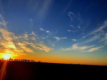 Scenic view of silhouette field against sky during sunset