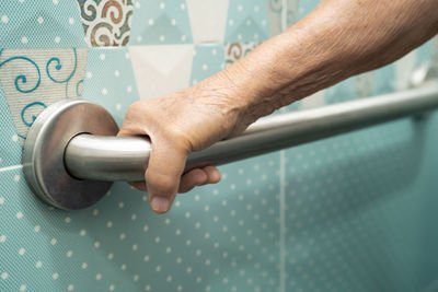 Cropped hand of man holding metal