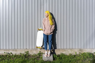 Full length portrait of woman standing against plants