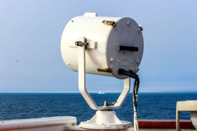 Close-up of coin-operated binoculars by sea against clear sky