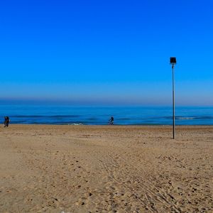 Scenic view of beach against clear blue sky