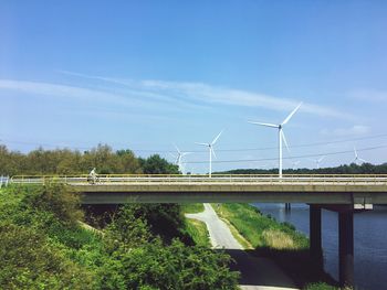 Windmills on field against sky