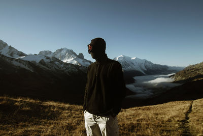 Rear view of man standing against mountain