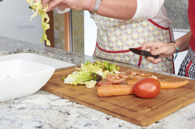 High angle view of woman preparing food on cutting board