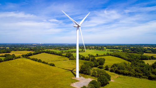 Windmills on field against sky