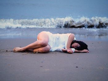 Woman lying on sand at beach