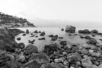 Rocks in sea against sky