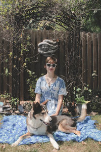 Young woman with dog against trees