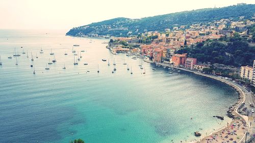 High angle view of sea and city against sky