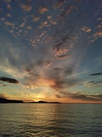 Scenic view of sea against dramatic sky during sunset