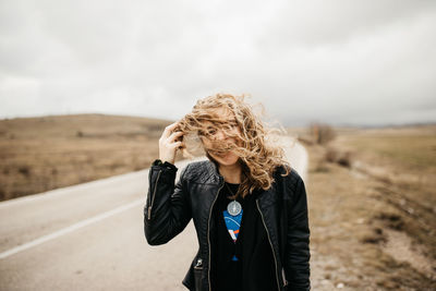 Full length of woman standing on road against sky