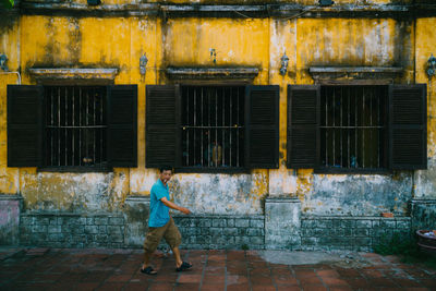 Full length of woman standing against building