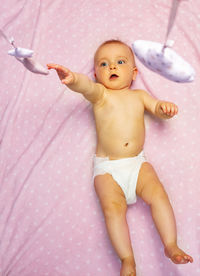 Portrait of cute baby boy lying on bed