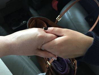 Cropped image of women handshake in vehicle