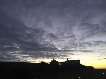 Low angle view of silhouette buildings against sky